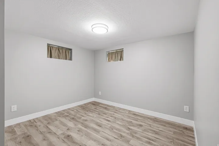 Lower level bedroom with laminate flooring and fresh neutral paint.