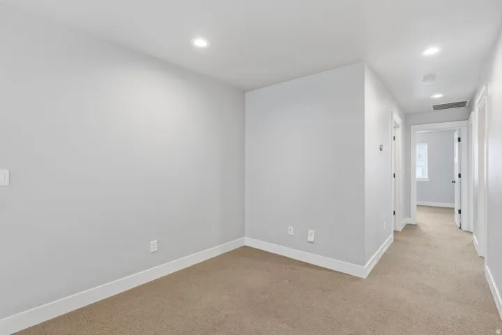Recessed lighting, light gray wall finishes, light tan carpet, white trim, and white doors