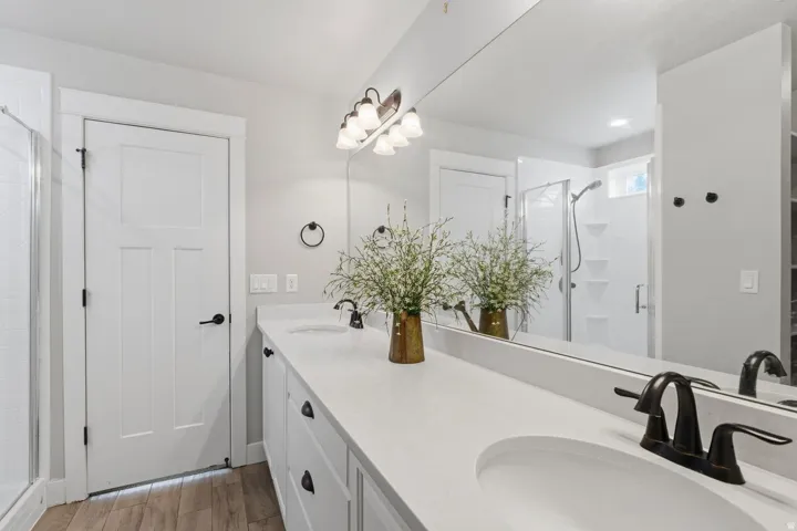 Double vanity with white cabinetry, integrated sinks, and dark bronze faucets