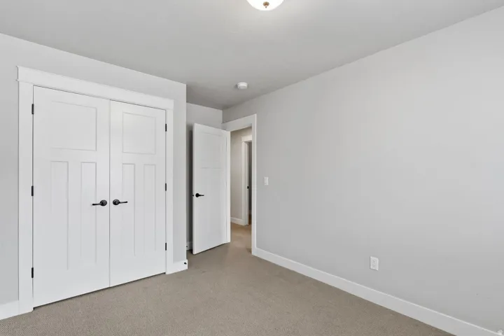 Wall-to-wall carpeting with light gray walls, white trim, and a white ceiling