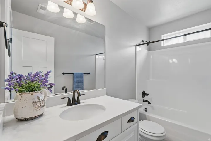 White vanity with an integrated sink and bronze-finish faucet