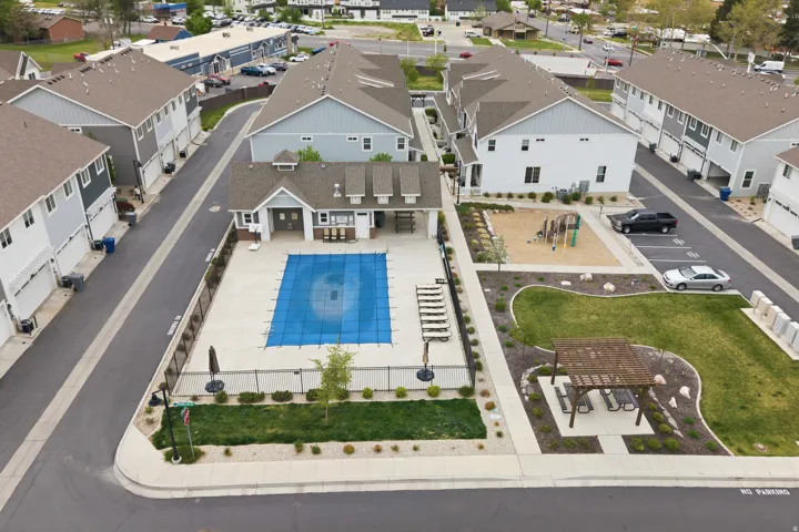 Community amenities featuring a swimming pool, shaded pergola, playground, and manicured green spaces