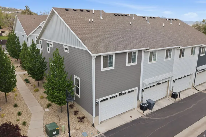 Contemporary townhome exterior with mixed siding, multiple windows, and individual garages