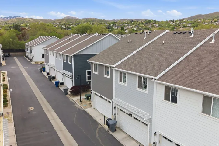 Row of multi-story townhomes featuring varied siding finishes and attached garages