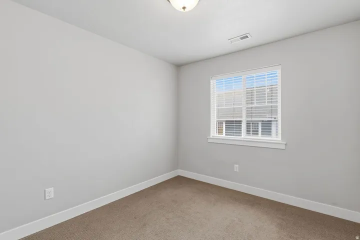 Neutral paint palette, carpeted flooring, and a single window with blinds