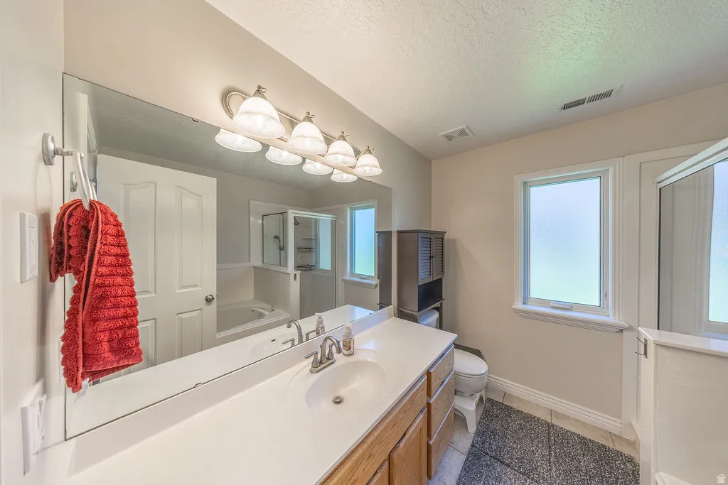 Expansive vanity with a single sink, light-toned countertop, and wood-finish cabinetry