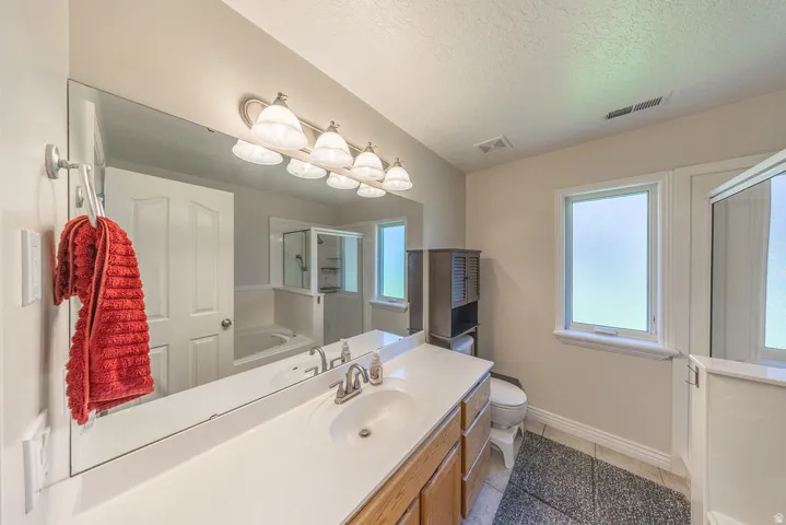 Expansive vanity with a single sink, light-toned countertop, and wood-finish cabinetry