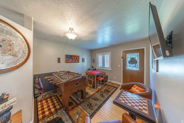 Wood-finish flooring, overhead lighting, and a paneled entry door with decorative glass
