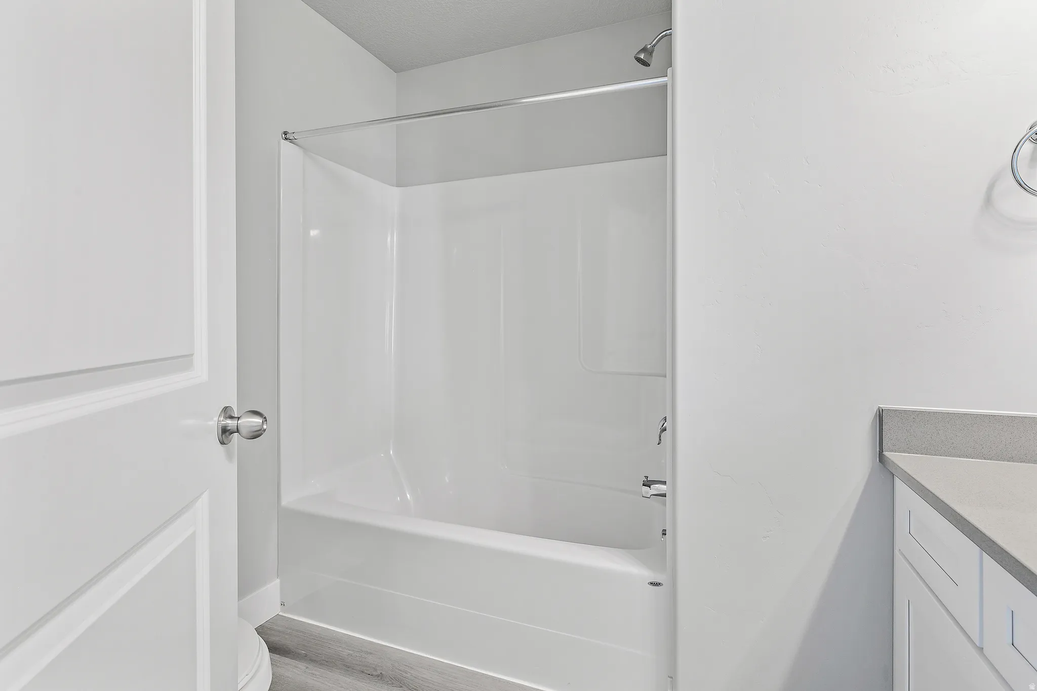 White tub/shower combination with a chrome shower head and fixtures