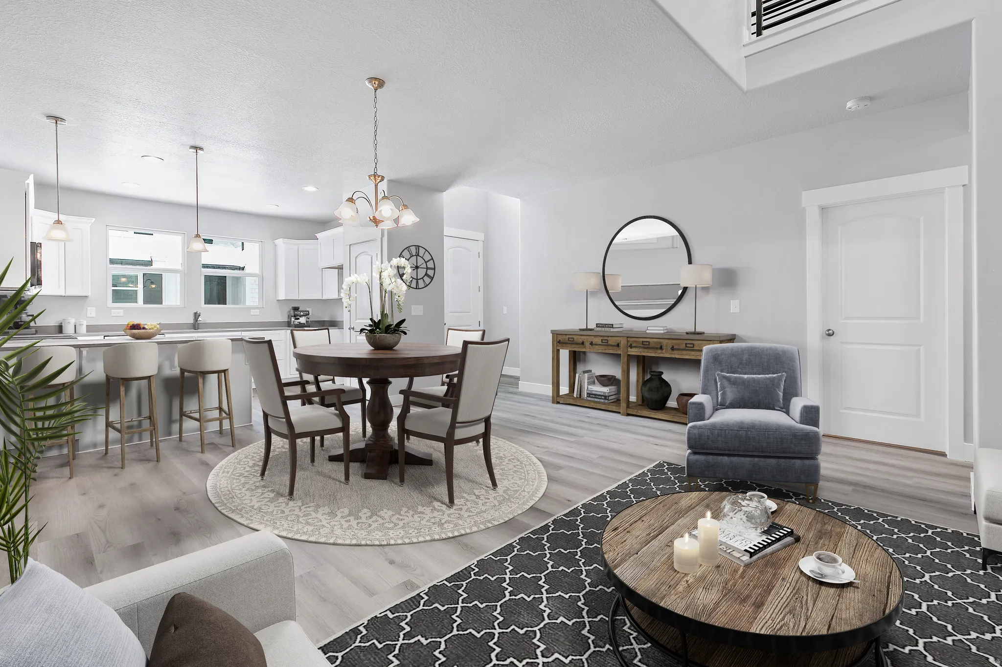 Open-concept living space with wood-finish flooring, white cabinetry, a built-in kitchen island, and recessed lighting