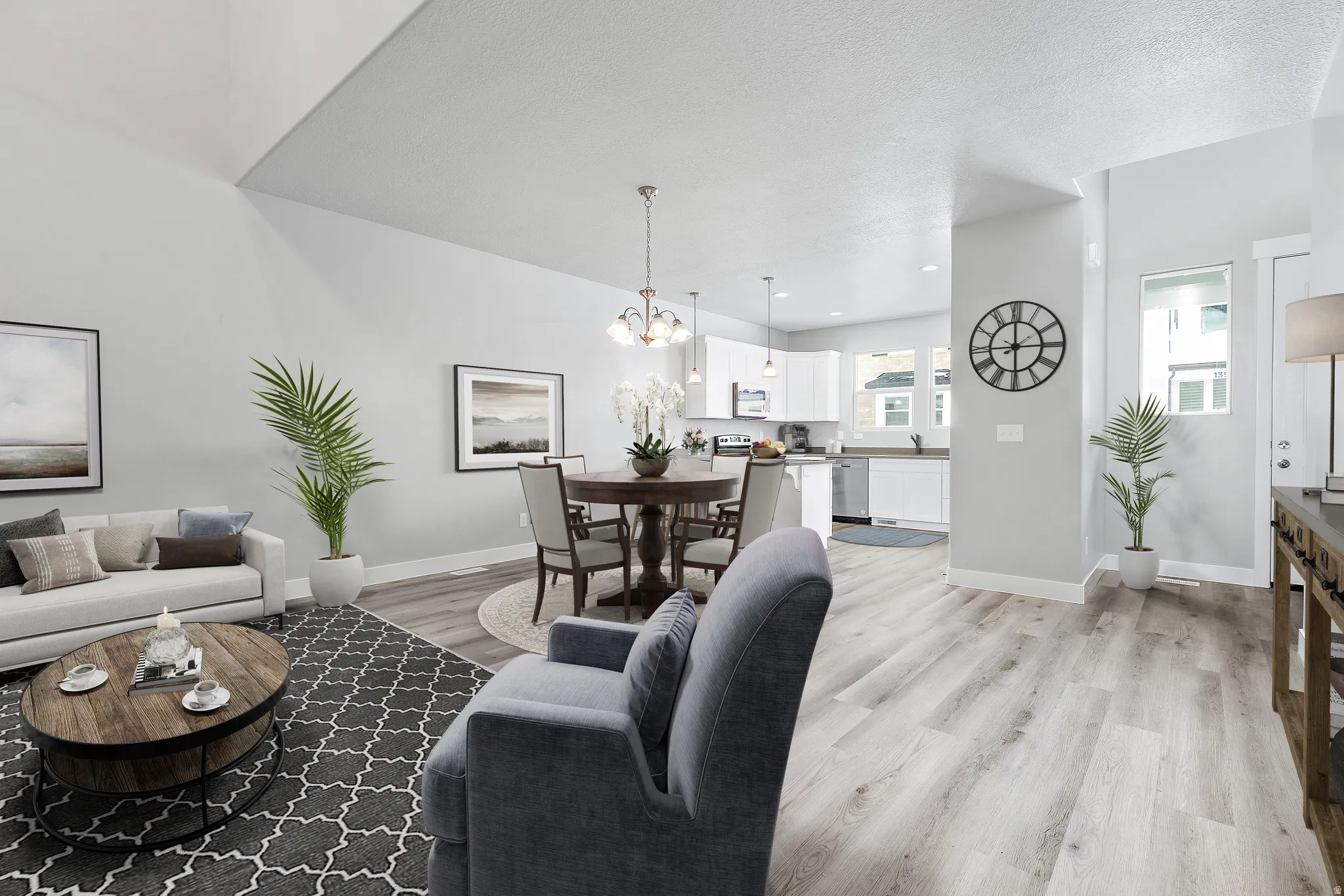 Vaulted ceilings, wood-finish flooring, recessed lighting, and a modern kitchen with white cabinetry