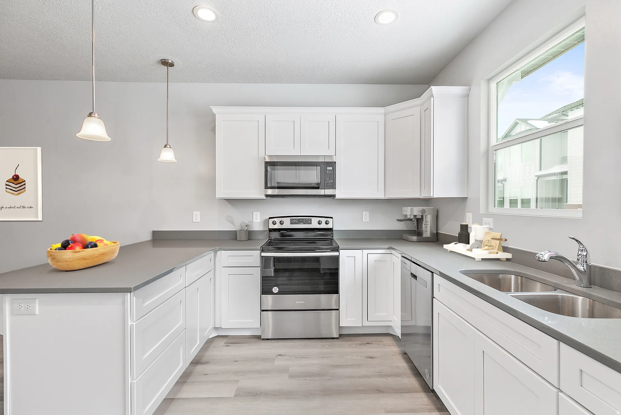 Modern kitchen featuring white cabinetry, grey countertops, stainless steel appliances, wood-finish flooring, and recessed lighting