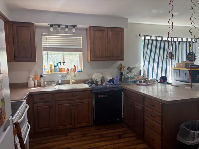 Kitchen with wood-finish flooring, wood cabinetry, and a double basin sink