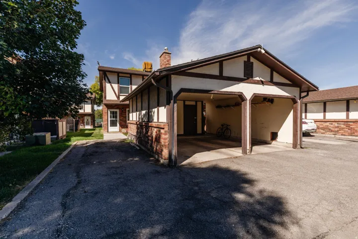 Tudor-style exterior featuring a carport and brick detailing