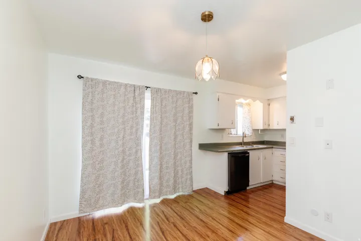 Wood-finish flooring, white walls, and a pendant light fixture