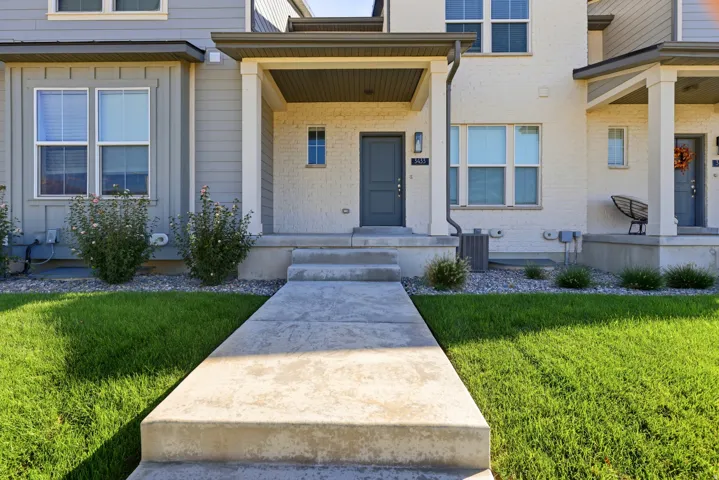 Contemporary exterior with brick and siding facade, covered entry, and concrete walkway