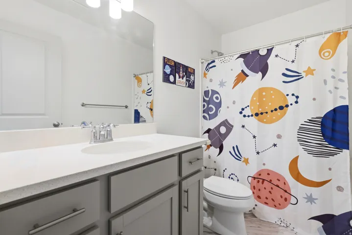 Vanity with light-toned countertop, undermount sink, and chrome faucet
