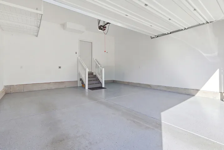 Epoxy-coated flooring, white walls, built-in overhead storage, and a separate entry door
