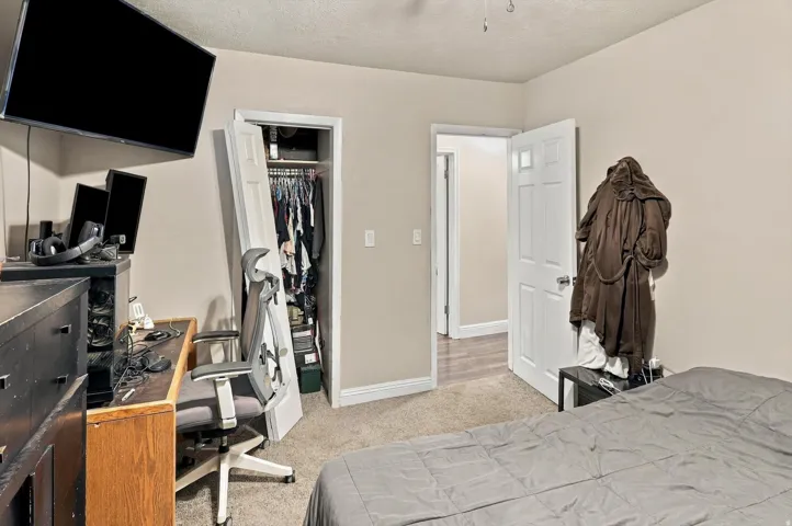 Wall-to-wall carpeting, neutral wall finishes, and a closet with bifold doors