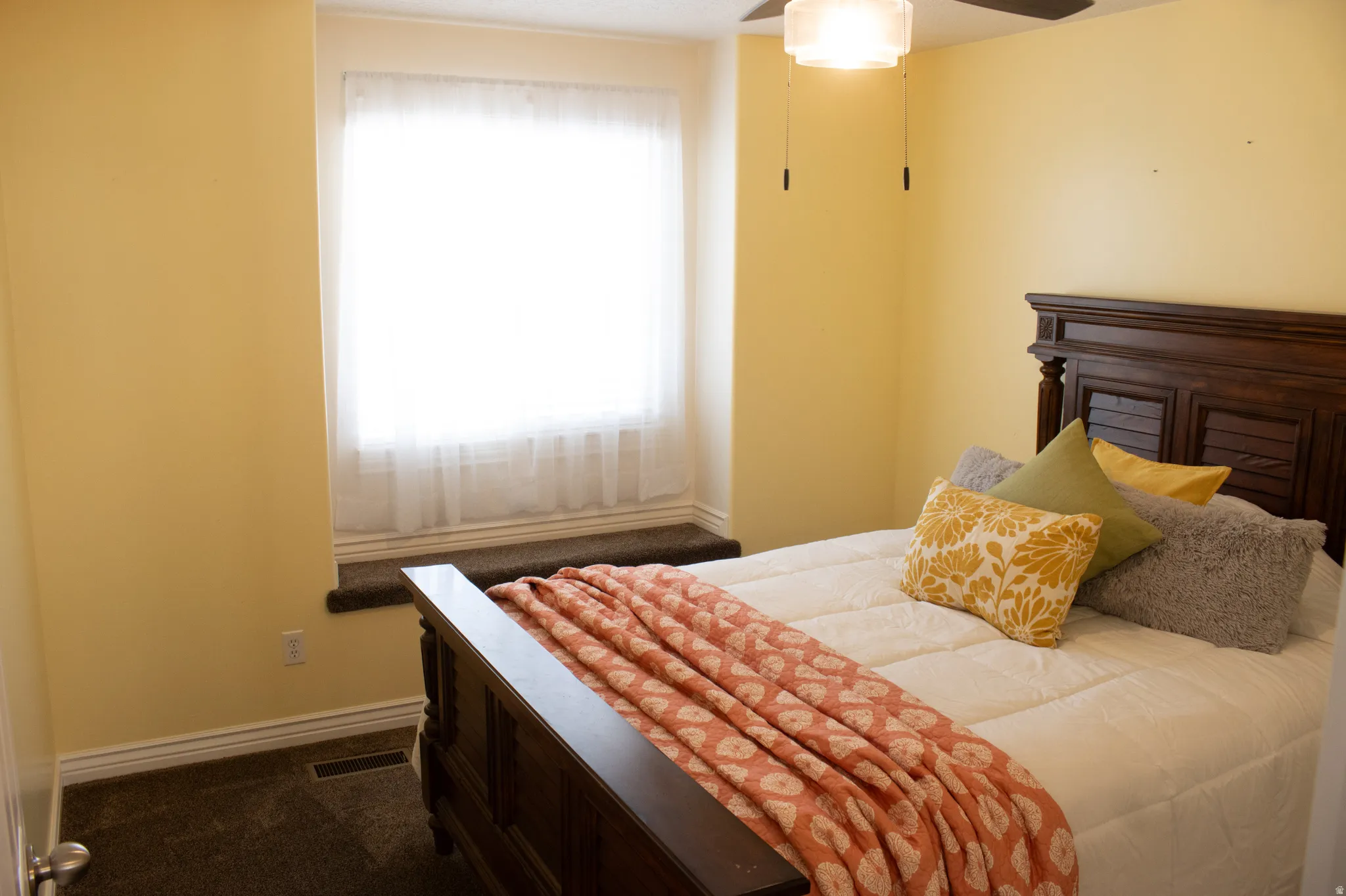Carpeted room featuring a window with a sill, a ceiling fan with integrated lighting, and painted walls