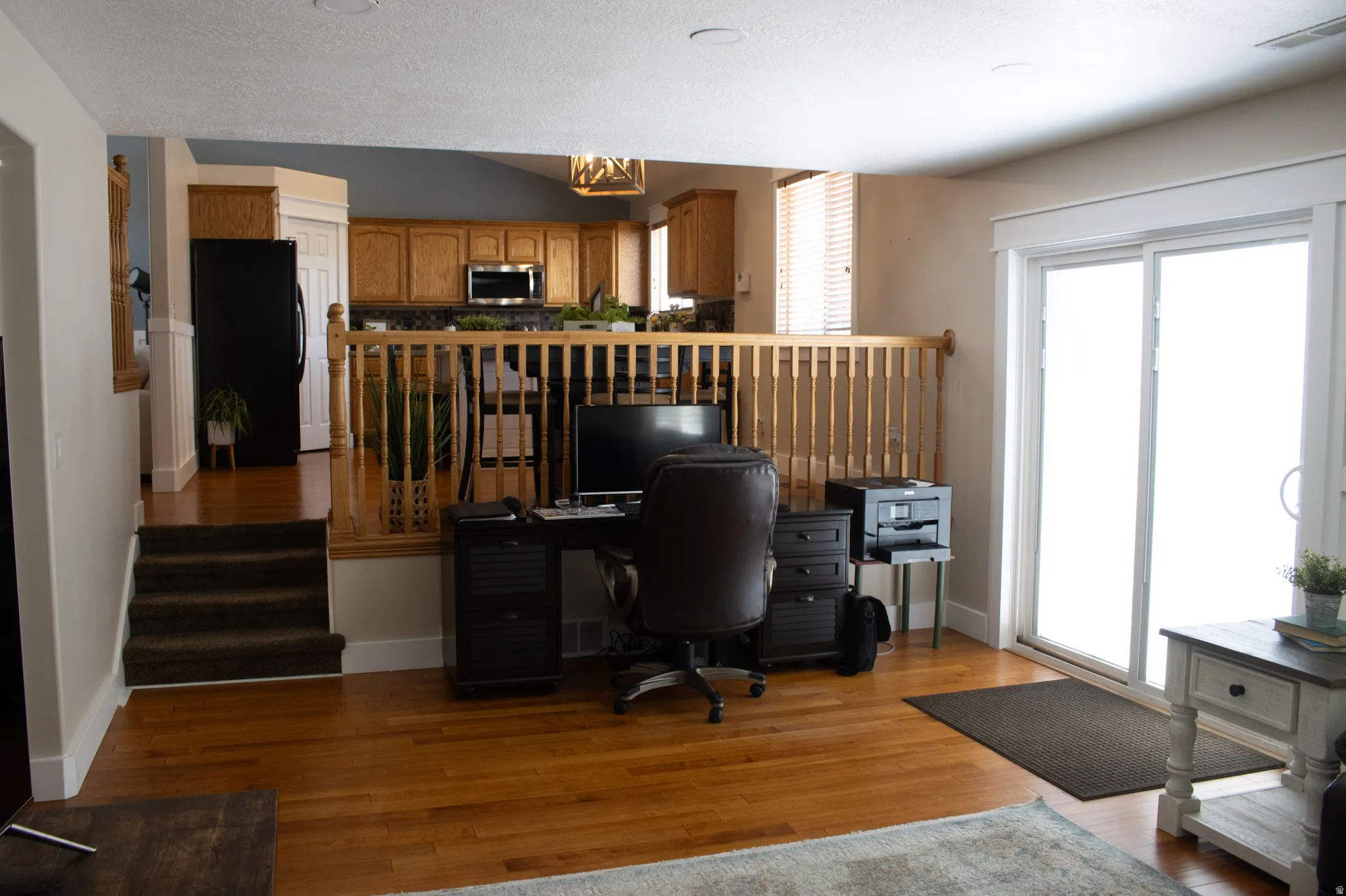 Hardwood-finish flooring, sliding glass door, recessed lighting, wood cabinetry, and stainless steel appliances