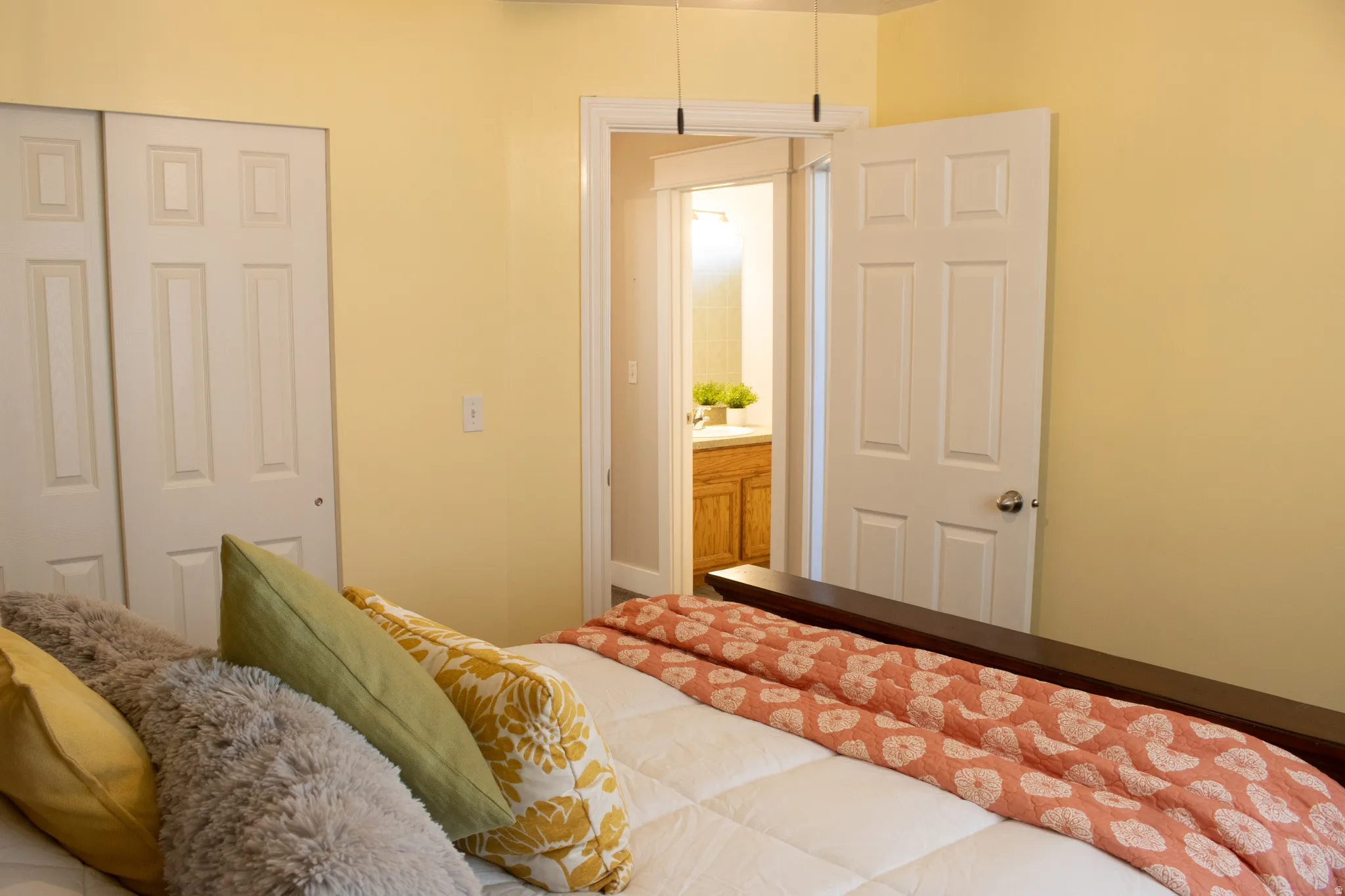 Sliding panel closet doors, paneled interior door, light wall color, built-in vanity with wood-finish cabinetry