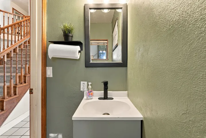 Bathroom vanity with integrated sink, matte black faucet, and framed mirror