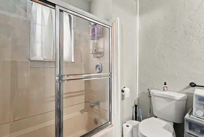 Shower-over-tub combination with chrome-framed glass enclosure