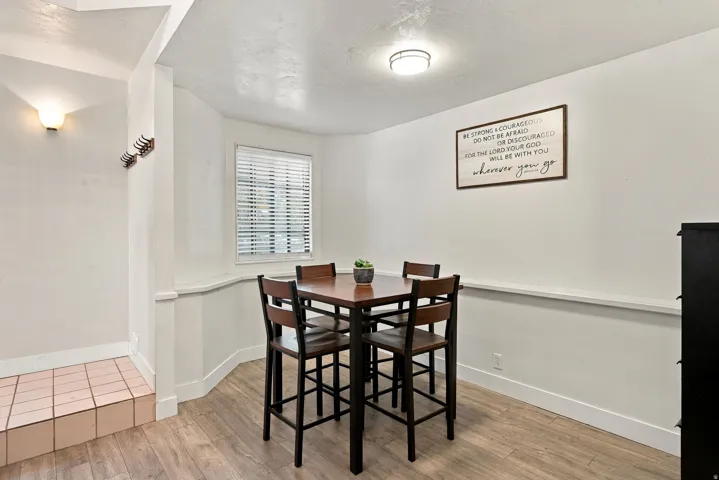 Wood-finish flooring, recessed lighting, wall sconce, and a window with blinds