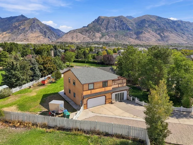 Two-story residence with an attached garage, a second-level balcony, and a paved driveway