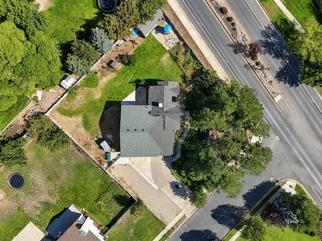 Expansive lot featuring mature trees, a driveway, and a fenced yard