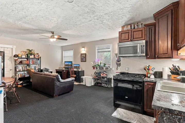 Kitchen with wood-finish cabinetry, built-in microwave, and black gas range