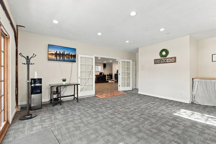 Recessed lighting illuminates the carpeted flooring