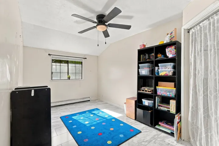 Recessed ceiling fan, window with horizontal blinds, baseboard heating, tile flooring