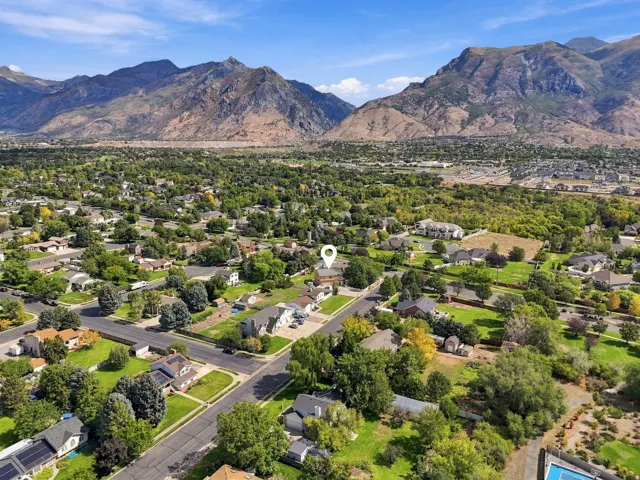 Expansive mountain range backdrop and neighborhood setting with mature trees and established residential properties