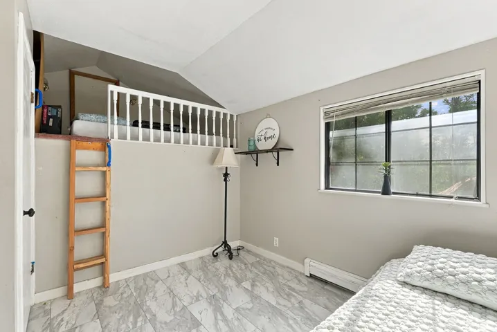 Loft area with white railing, wood ladder, and gray wall paint