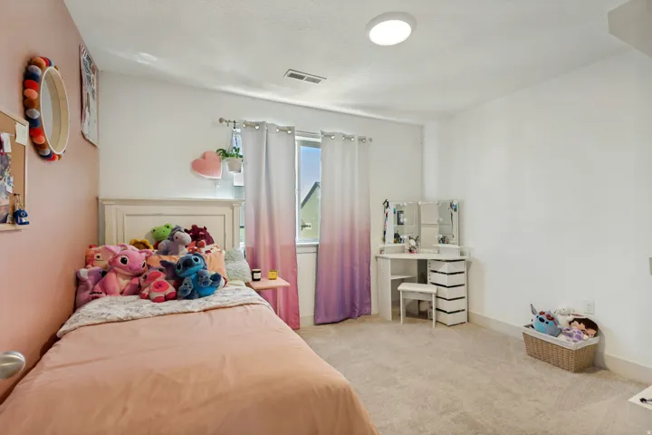 Plush carpet flooring, white painted walls, window with natural light, white trim, and a flush mount ceiling light