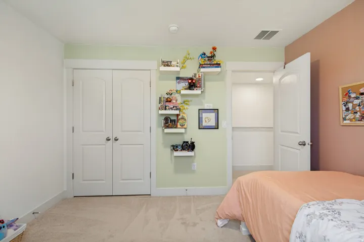 Neutral carpeting, white trim, recessed lighting, double-door closet, and an open closet with built-in shelving