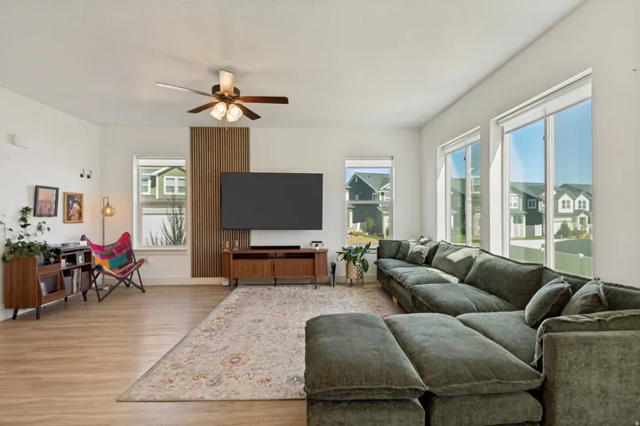 Recessed lighting, wood-finish flooring, ceiling fan with integrated lighting, and multiple large windows