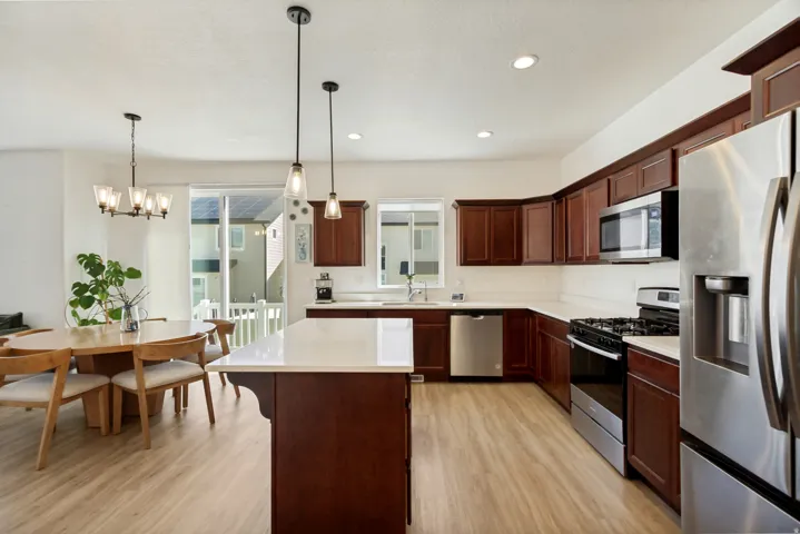 Kitchen featuring wood-finish flooring, dark wood cabinetry, and stainless steel appliances