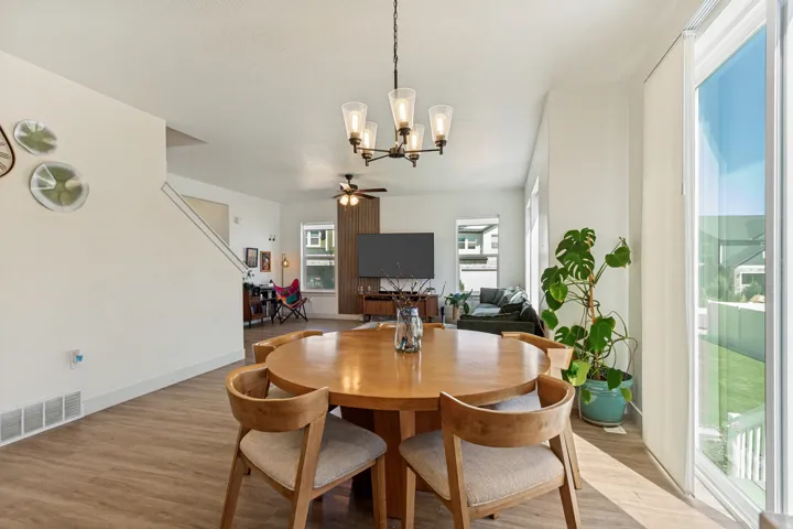 Open-concept living area featuring wood-finish flooring, a contemporary chandelier, and large sliding glass doors