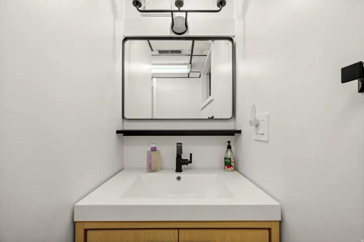 Floating wood-finish vanity with an integrated sink and white countertop