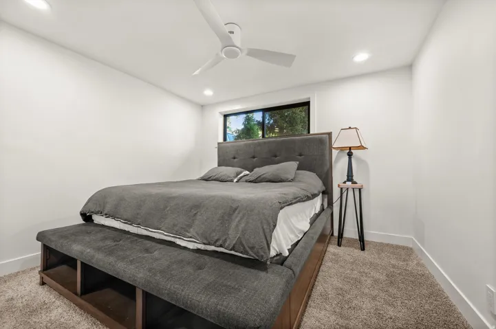 Recessed lighting, ceiling fan, window with dark trim, light-colored walls, and carpet flooring