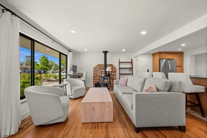 Hardwood flooring throughout, recessed lighting, and a stone-clad wood-burning stove