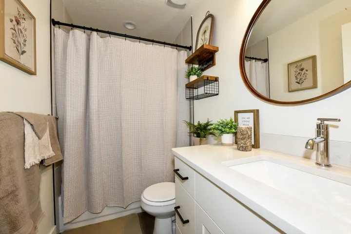 White vanity with black hardware, integrated sink, and polished chrome faucet