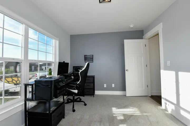 Walls with two-tone paint finish, large multi-pane windows, and a carpeted floor