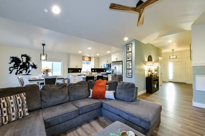 Open-concept living area with wood-finish flooring, recessed lighting, and a modern ceiling fan