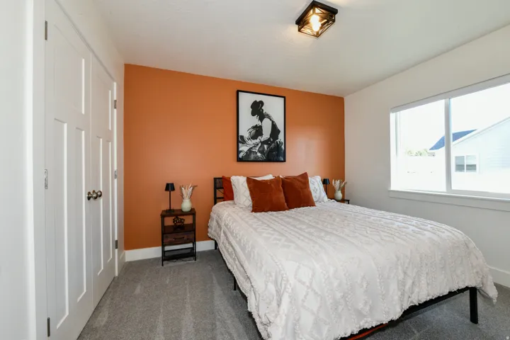 Recessed paneled closet doors, accent wall, large window, and flush mount ceiling light fixture