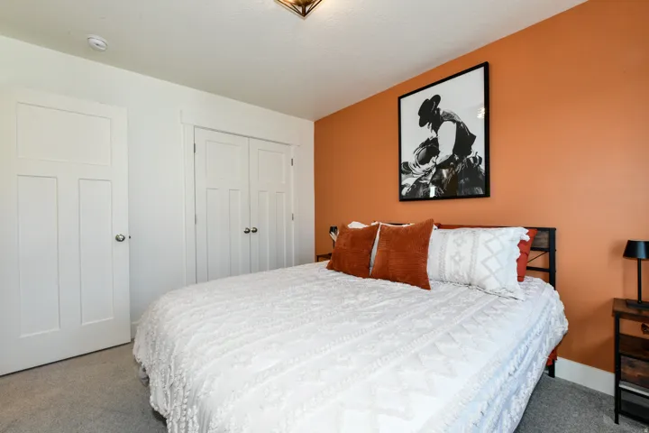 White trim details, white paneled doors, dual-door closet, ceiling-mounted light fixture, and carpeted flooring