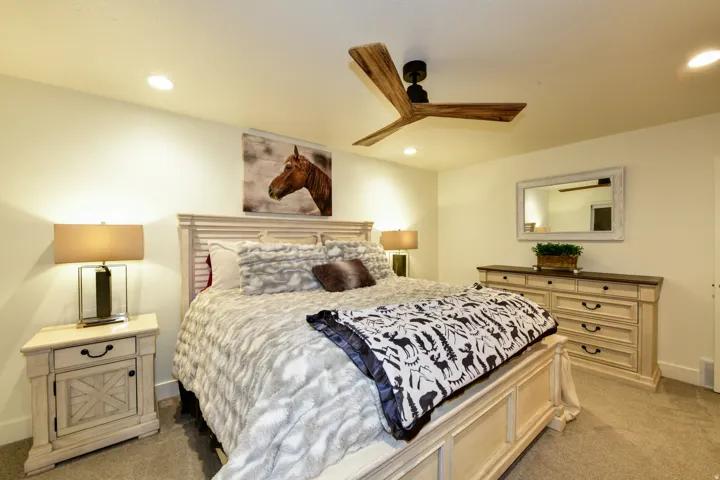 Recessed lighting, wood-finish ceiling fan, and carpeted flooring
